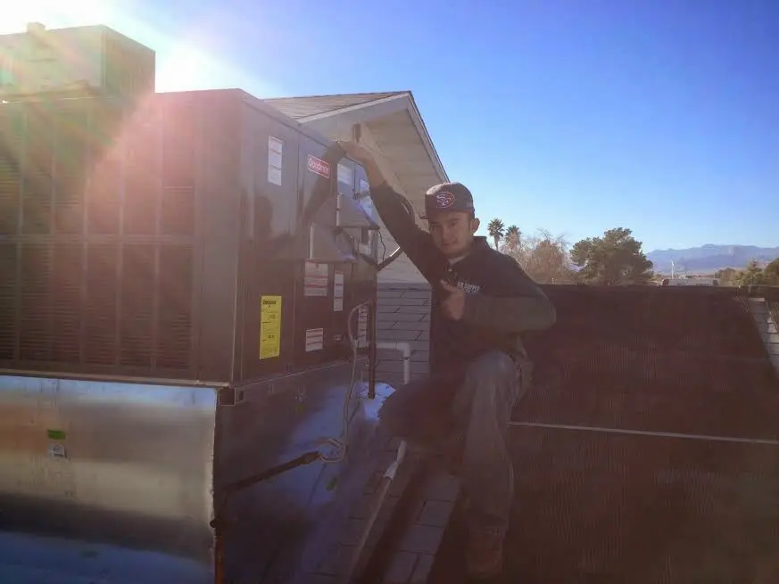 HVAC technician performing Boiler Repair on a rooftop unit in White Oak